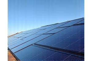 Monocrystalline solar panels on a residential rooftop under bright sunlight.